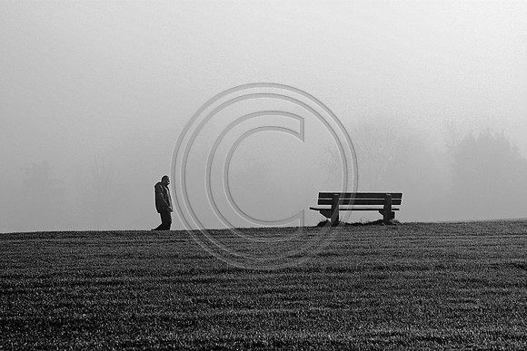 Man and bench in fog